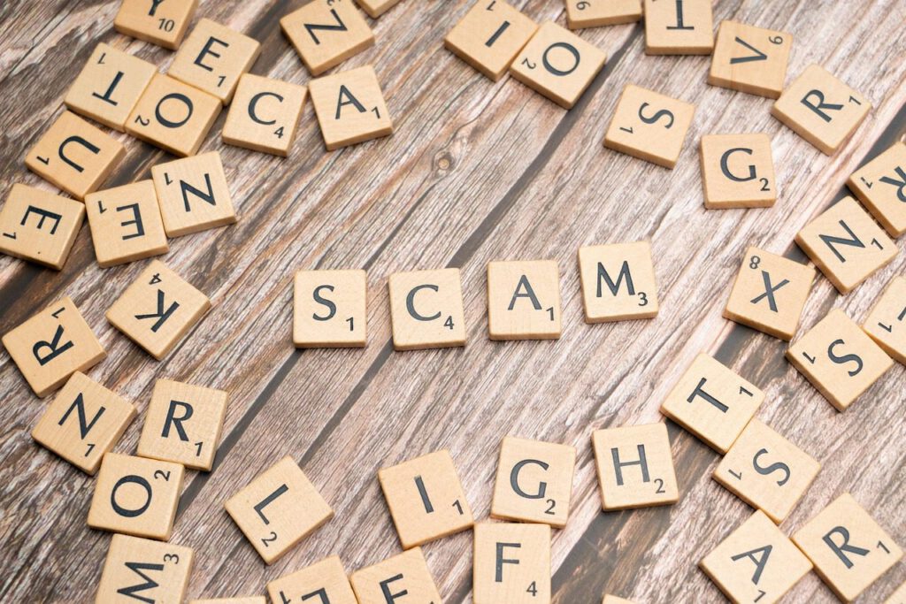 Scrabble tiles spelling 'scam' representing the bank investigator scam and online fraud threats.