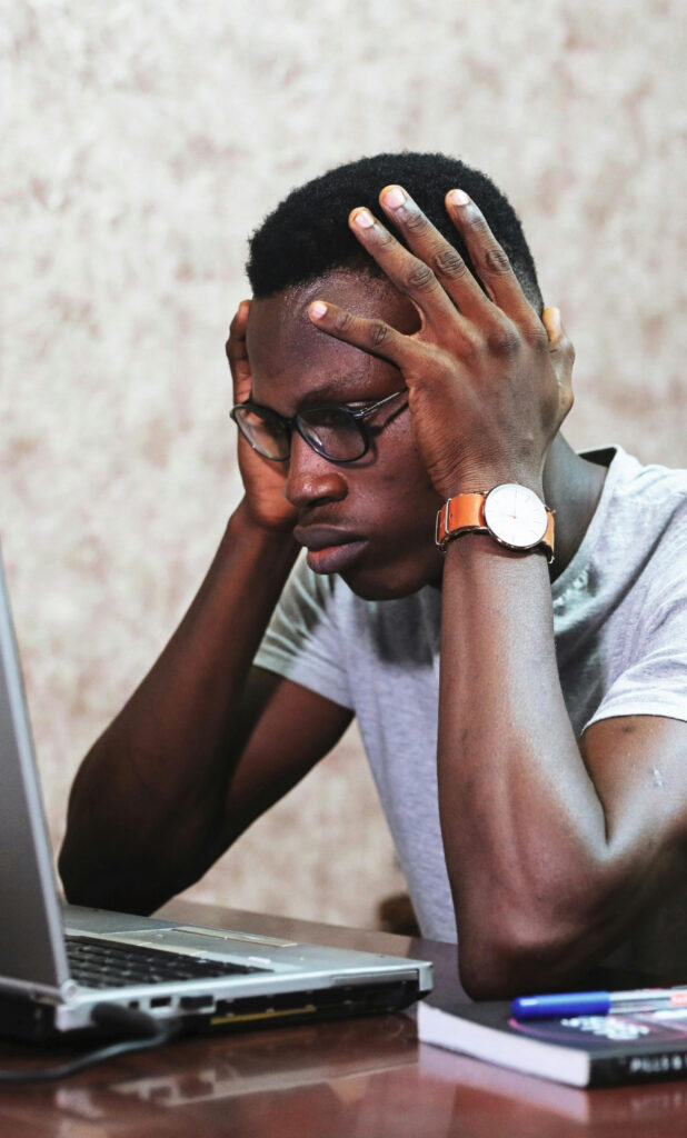 Frustrated man looking at his computer needing Mac Virus and Malware Removal