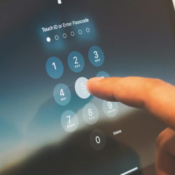 Person entering a passkey into their iPhone as part of multi-factor authentication setup.