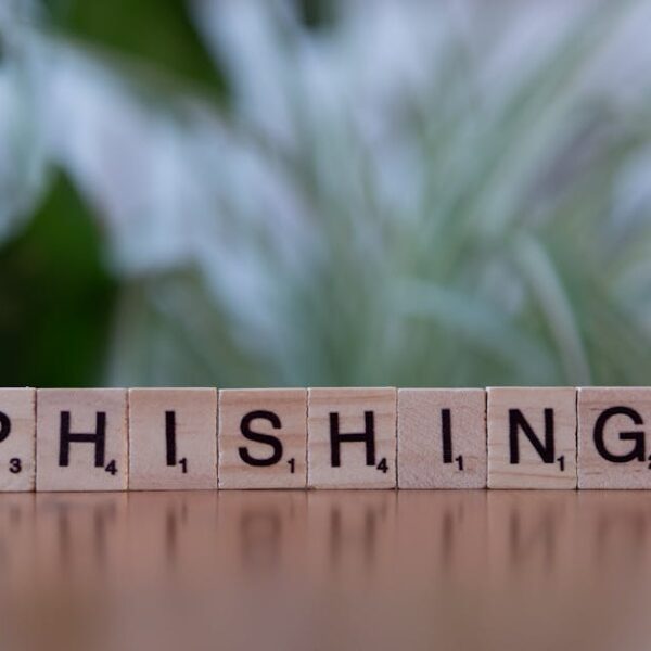 Scrabble tiles spelling “PHISHING” on a blurred background, symbolizing online scams and cyber threats.